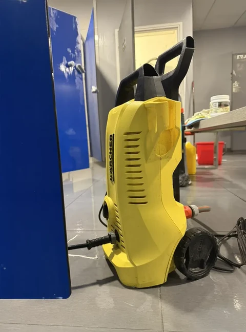 Intérieur d'un bâtiment commercial avec nettoyeur haute pression jaune Kärcher posé au sol