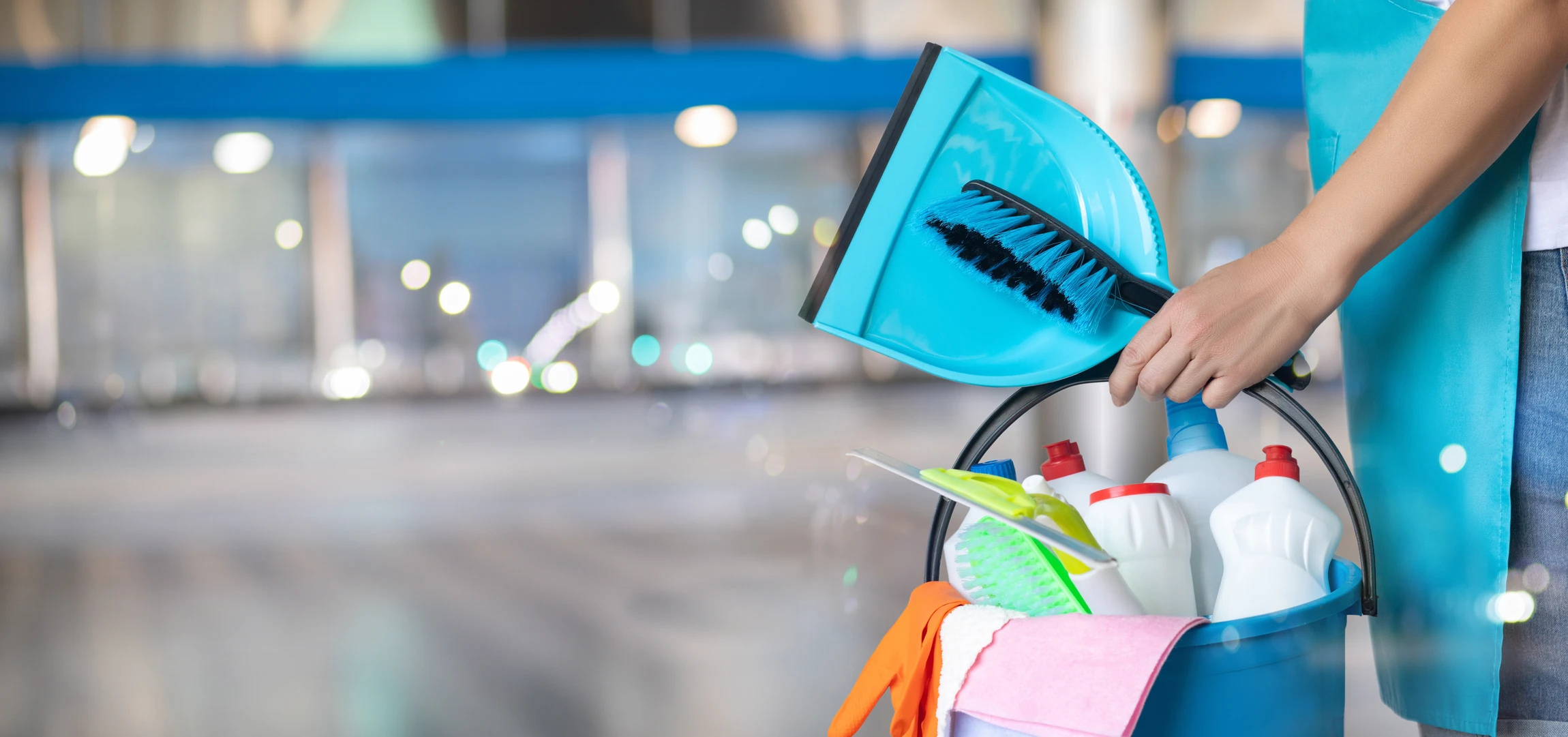 Scène d'entretien professionnel dans un bureau moderne avec employé en combinaison bleue effectuant le nettoyage du sol